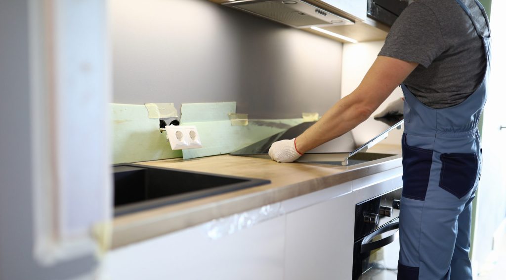 Tradesman Installs Hob appliance in kitchen